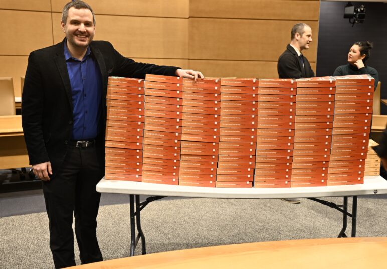 Chris Meyer stands by a table weighed down with copies of Donald Shoup's book "The High Cost of Free Parking"